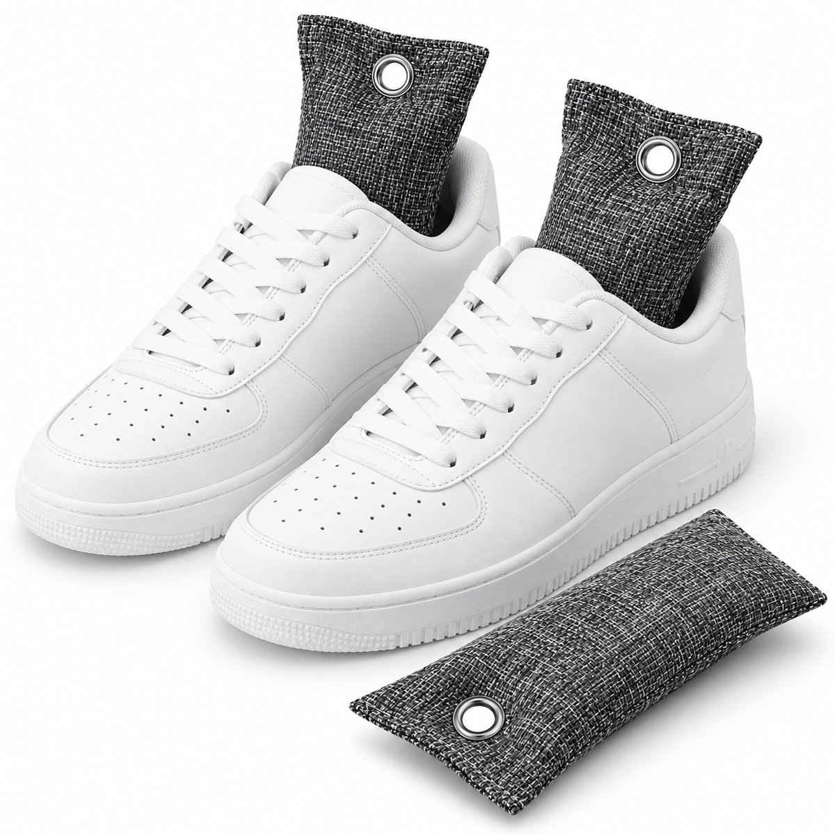 A pair of white low-top sneakers with dark gray fabric shoe socks and a matching gray foot odor absorber mat on a clean white background.